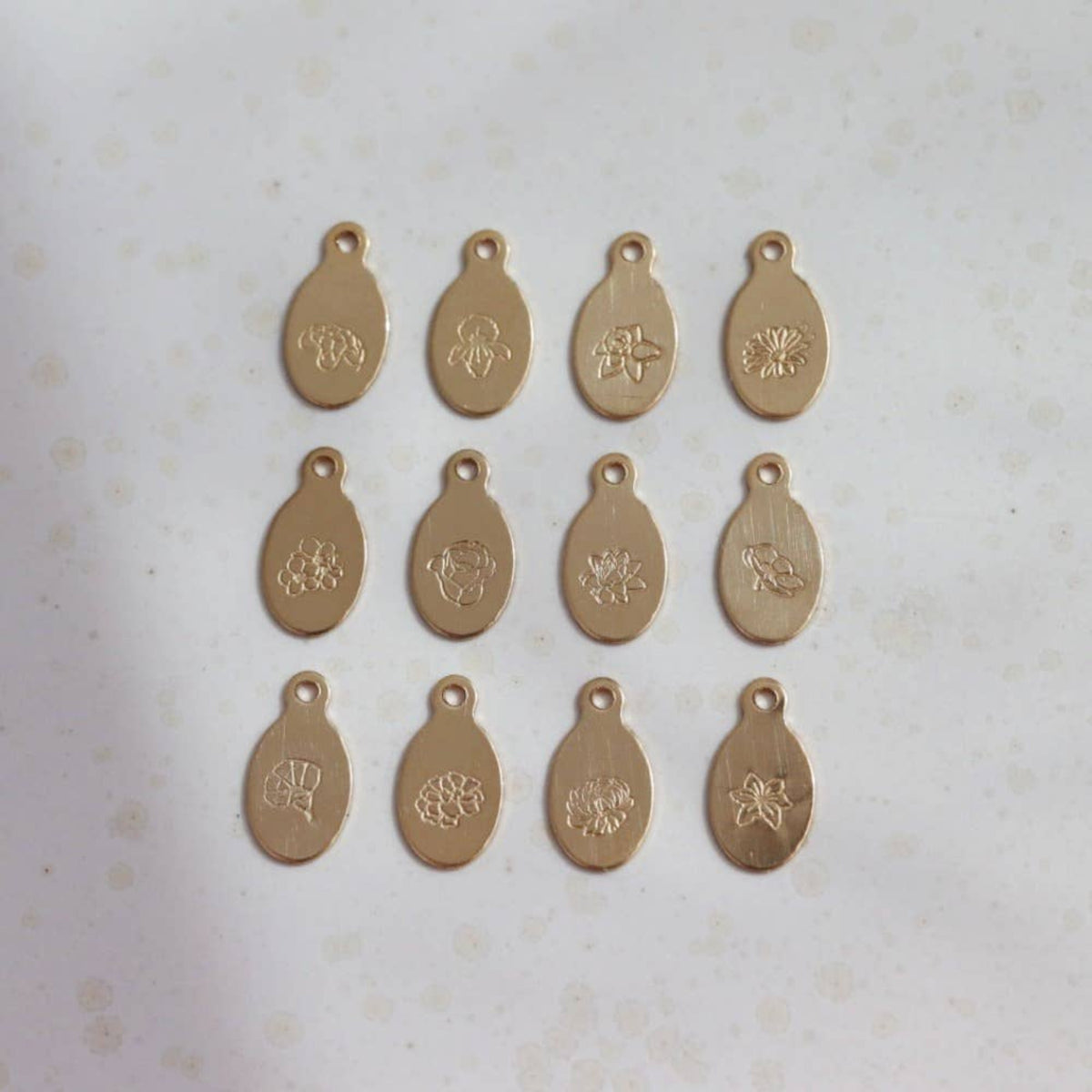 Golden necklace pendents with birth flowers for all months. 