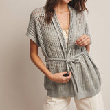Woman wearing a Sage knit Cardigan with open knit and waist tie 