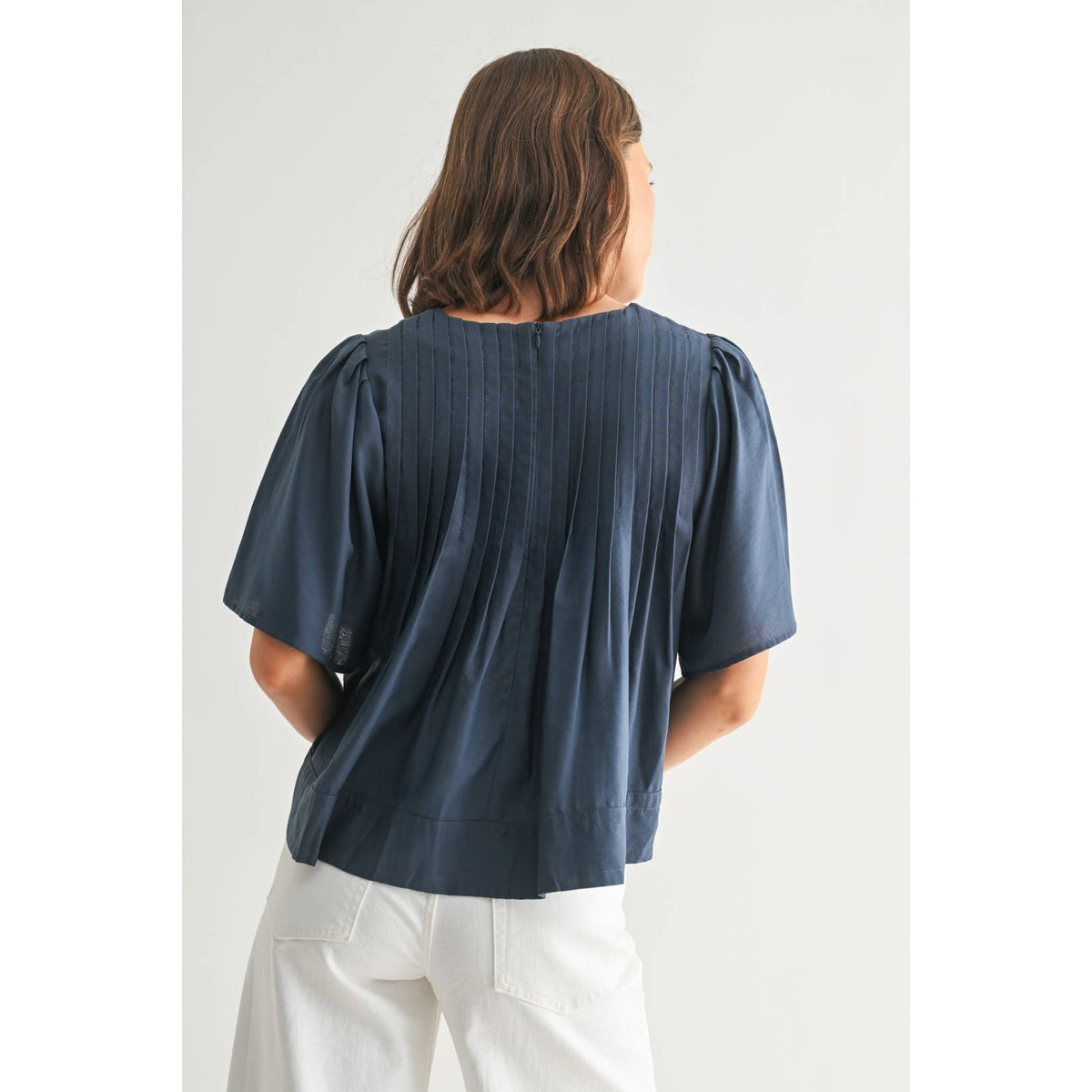 Person wearing a blue blouse with puffed sleeves on a white background