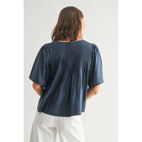 Person wearing a blue blouse with puffed sleeves on a white background