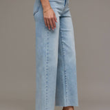 Light blue jeans worn by a person on a neutral background