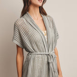 Woman wearing a Sage knit Cardigan with open knit and waist tie 