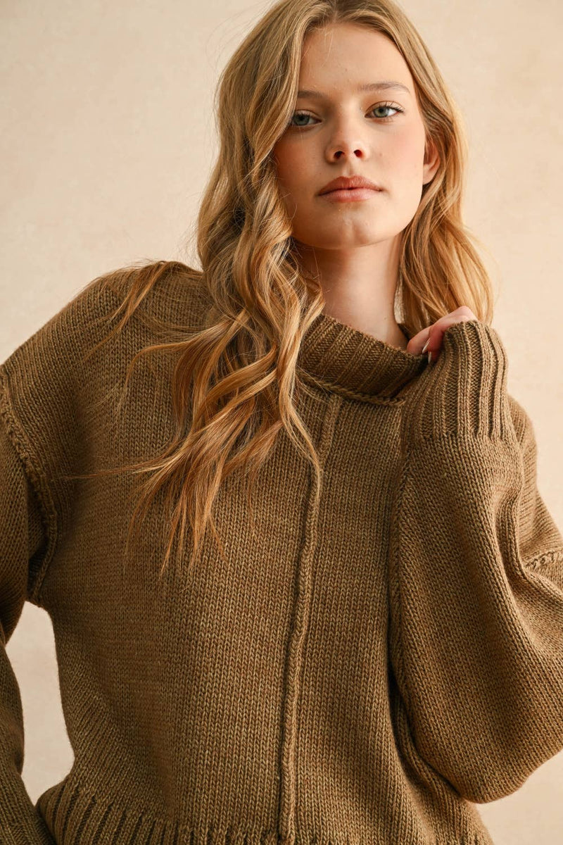 Woman wearing a brown knitted sweater against a beige background