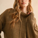 Woman wearing a brown knitted sweater against a beige background