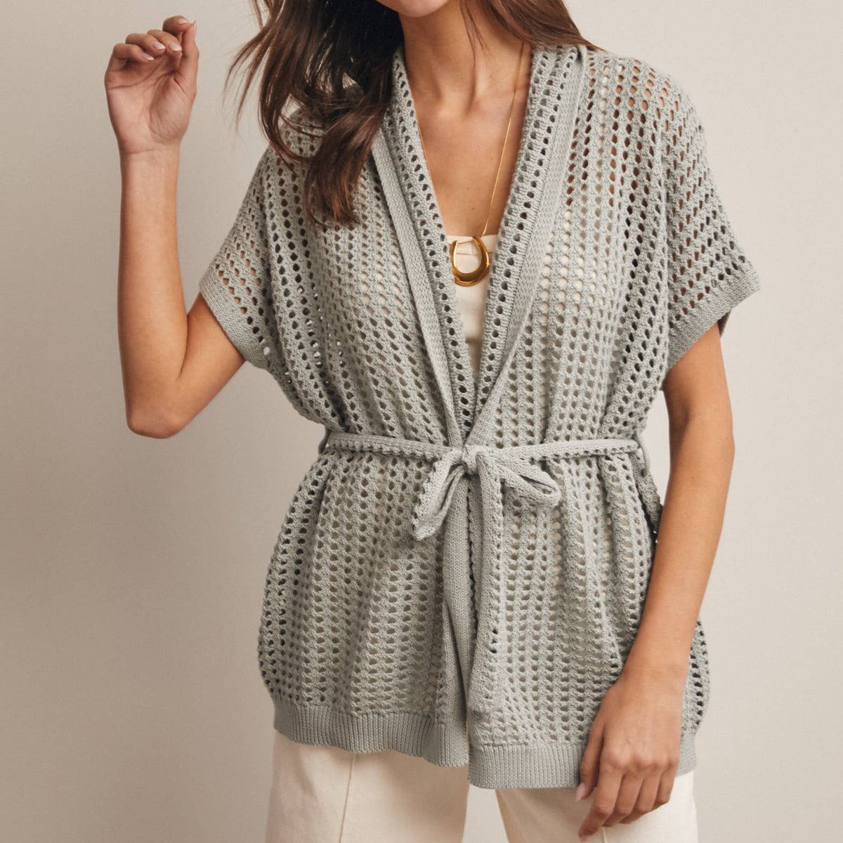 Woman wearing a Sage knit Cardigan with open knit and waist tie