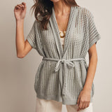 Woman wearing a Sage knit Cardigan with open knit and waist tie