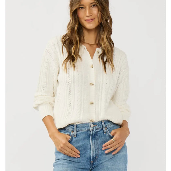 Woman wearing a white button-up shirt and blue jeans on a light gray background