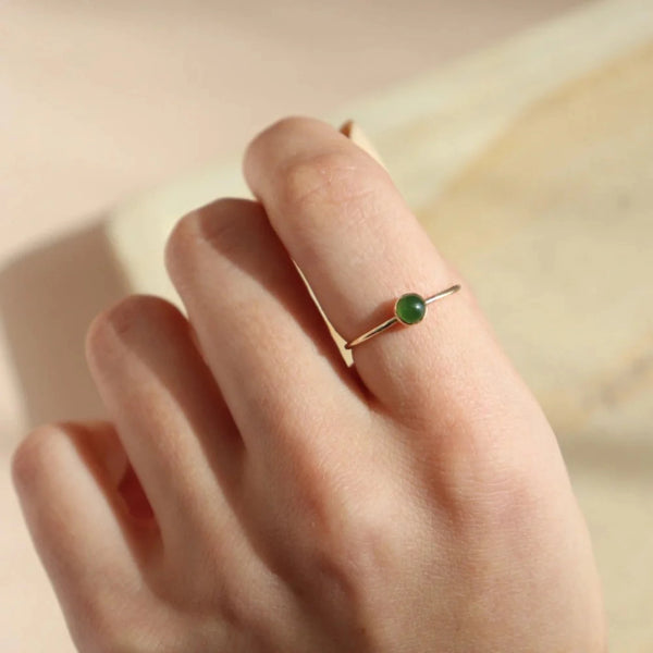 Small  jade stone ring with golden band; accessory.