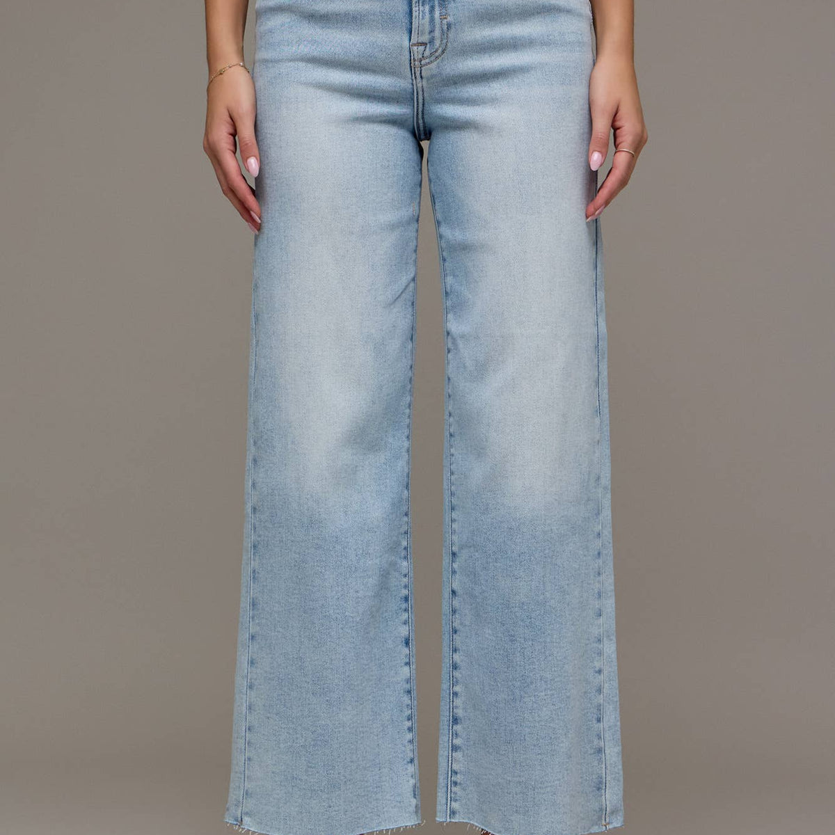 Light blue jeans worn by a person on a plain background