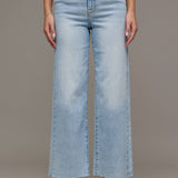 Light blue jeans worn by a person on a plain background