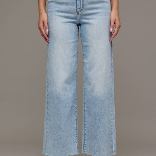 Light blue jeans worn by a person on a plain background