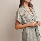 Woman wearing a Sage knit Cardigan with open knit and waist tie 