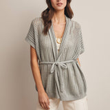 Woman wearing a Sage knit Cardigan with open knit and waist tie 